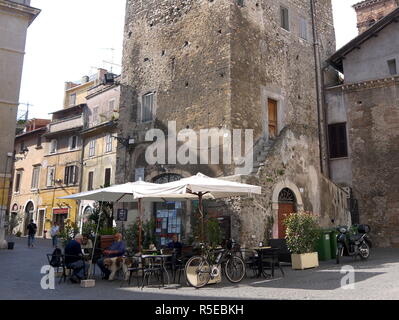TIVOLI, ITALY - SEPTEMBER 29, 2017: People and dog at a coffee shop on the street in the old town of Tivoli early morning