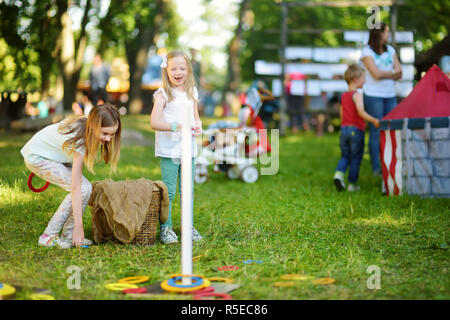 Children playing ring toss game during annual Medieval Festival, held in Trakai Peninsular Castle. Recreating medieval town spirit. Stock Photo