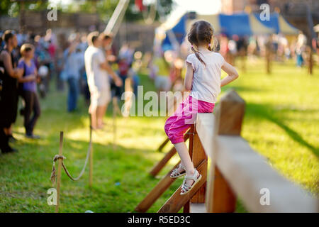 Children having fun during annual Medieval Festival, held in Trakai Peninsular Castle. Recreating medieval town spirit. Stock Photo