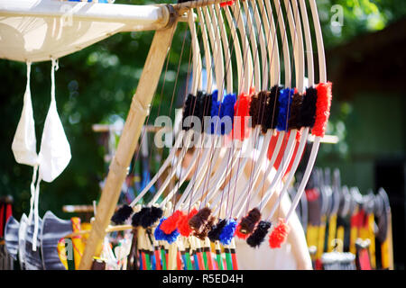 Toy medieval armour, helmets and wooden weapons sold on market stall during annual Medieval Festival, held in Trakai Peninsular Castle. Stock Photo