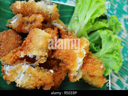 fried fish crispy / close up fried fish fillet with bread crumb and vegetable on plate / slice of tilapia fish cook fry crispy Stock Photo