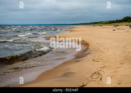 storm clouds forming over clear sea beach with rocks and clear sand. dramatic colors Stock Photo