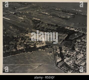 Aerial view of Municipal Offices and Victoria Terminus, Bombay. The Victoria Terminus with platforms and sidings to the north takes up the central portion of this print, with the Municipal Offices and Maidan in the foreground.The General Post Office is to the right, with the Docks beyond. Aerial Photographs of Bombay. 1937. Photograph. Source: Photo 91/(5). Author: UNKNOWN. Stock Photo