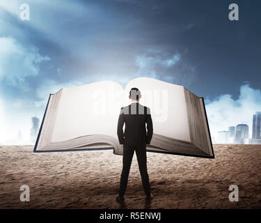 Young business man reading big book Stock Photo