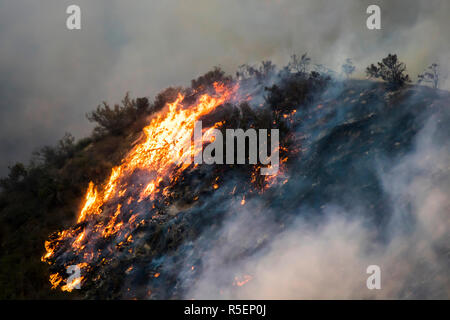 Wildfire flames burn hillside brush at night with dramatic shapes and color in California's Woolsey Fire Stock Photo