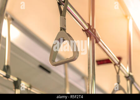 Handles on ceiling for standing passenger inside a bus Stock Photo