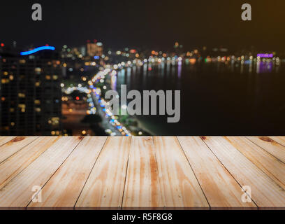 Empty wooden table with blurred city skyline background  at night Stock Photo