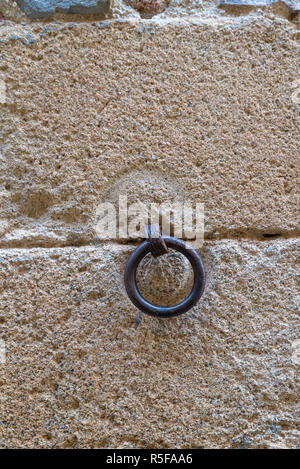 iron hoop hanging from stone wall Stock Photo