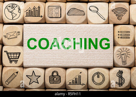 Coaching Text On Wooden Block Surrounded By Computer Icons Stock Photo