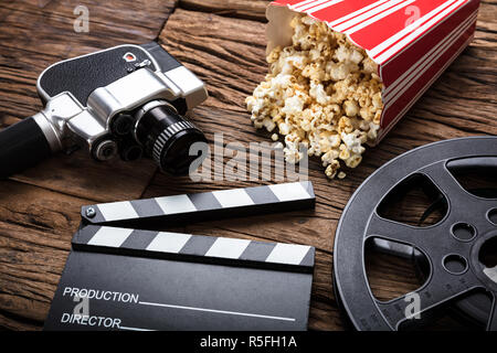 Movie Camera With Clapper Board And Popcorn On Wood Stock Photo