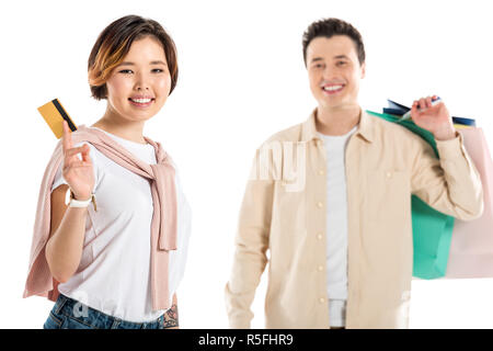 smiling husband carrying shopping bags while happy wife presenting credit card isolated on white Stock Photo
