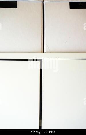 Two White Storage Boxes On Top Of A Wardrobe Stock Photo