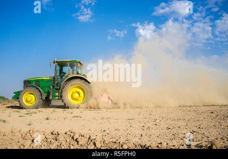 Badajoz, Spain - Oct 11th 2017: Farm tractor preparing dusty soil affected by drought. Drought and agriculture concept Stock Photo