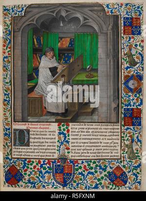 Vincent de Beauvais reading at his desk, with a large magnifying glass beside him. In the background, books are placed on sloping shelves. Borders of foliate decoration, with the arms of King Edward IV, for whom the manuscript was produced. Decorated initial 'P'. Speculum Historiale, Book 1. S. Netherlands [Bruges]; late 15th century. Source: Royal 14 E. I, f.3. Language: French. Stock Photo