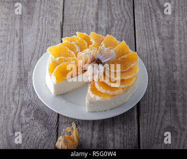 Cheesecake decorated with oranges and physalis Stock Photo