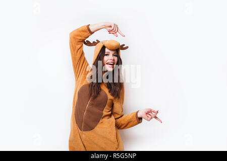 Funny young woman in pajamas standing and showing to the side on white background . Stock Photo