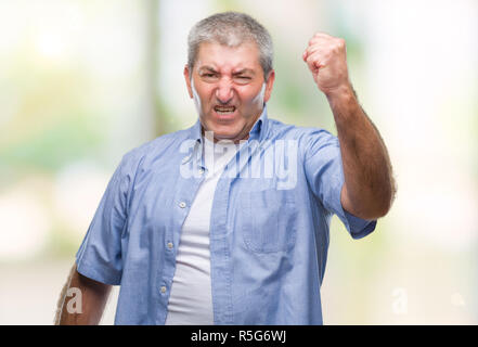 Handsome senior man over isolated background angry and mad raising fist frustrated and furious while shouting with anger. Rage and aggressive concept. Stock Photo