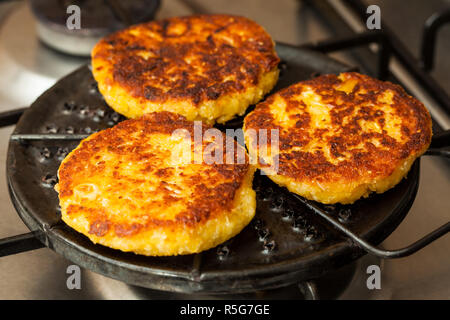 Corn breads being roasted on a round grill Stock Photo