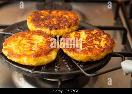 Corn breads being roasted on a round grill Stock Photo