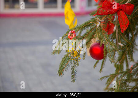 horizontal image with Christmas subject, of a red Christmas ball hanging from a tree branch with a red bow Stock Photo