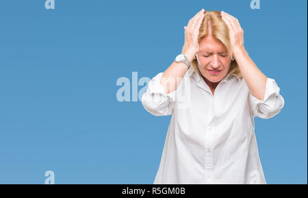 Middle age blonde business woman over isolated background suffering from headache desperate and stressed because pain and migraine. Hands on head. Stock Photo