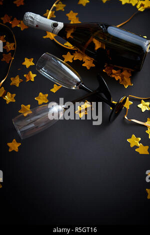 Glasses and bottle of champagne with golden serpentines and confetti Stock Photo