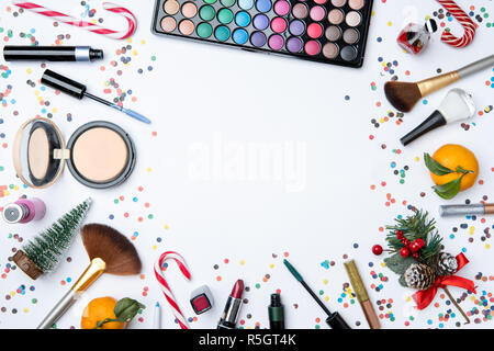 Picture on top of eye shadows, brushes, , tangerine, sugar cane on empty white table Stock Photo