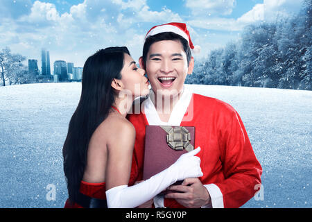 Santa woman give kiss to her lover Stock Photo