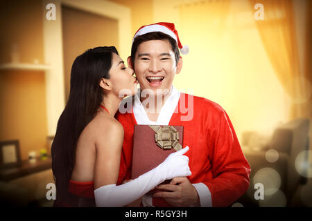 Santa woman give kiss to her lover Stock Photo