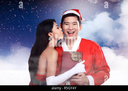 Santa woman give kiss to her lover Stock Photo