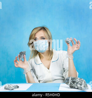 A woman lab worker examines stones for anilization, the content of harmful asbestos. Stock Photo