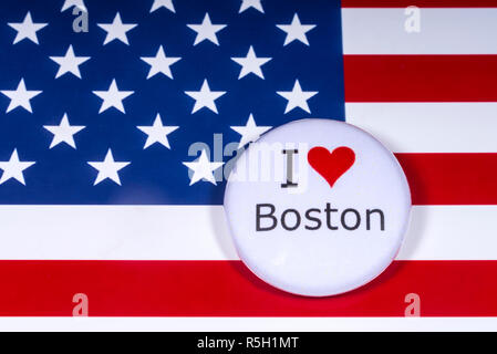 London, UK - November 15th 2018: An I Love Boston pin badge, pictured over the flag of the United States of America. Stock Photo