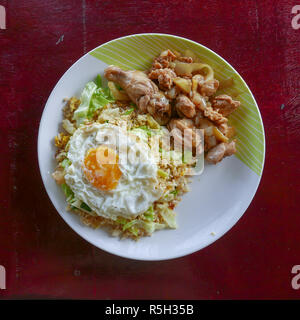 Authentic Malaysian food from family street restaurant in Perhentian Islands. Fried rice with chicken, omelet plate on textured background. Delicious Stock Photo