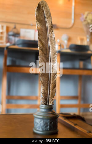 Metal bird feather on leather background Stock Photo
