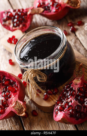 Freshly prepared delicious thick pomegranate sauce in a jar closeup on the table. vertical Stock Photo