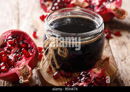 Azerbaijani seasoning Narsharab sauce made from pomegranate juice in a jar close-up on the table. horizontal Stock Photo