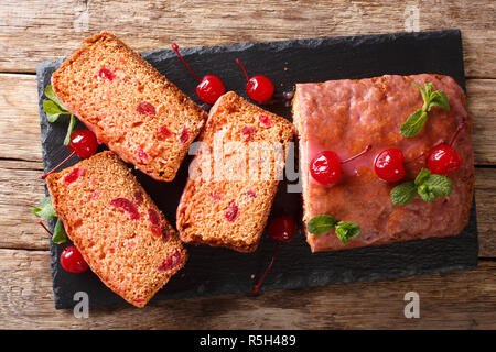 Soft glazed bread with maraschino cherries, mint close-up on the table. Horizontal top view from above Stock Photo