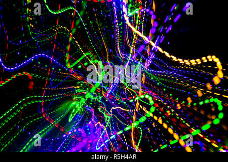 The chaotic lines of color lights on dark background. Colorful lights is move in the black space. Stock Photo