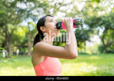 Sport Woman drinking water in park Stock Photo