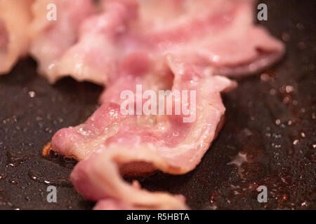 Frying pan with cooked bacon rashers on white background Stock Photo - Alamy