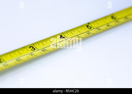 A Close Up Of A Yellow Metric Tape Measure With A White Hand Holding It  Close For Precision Stock Photo - Download Image Now - iStock