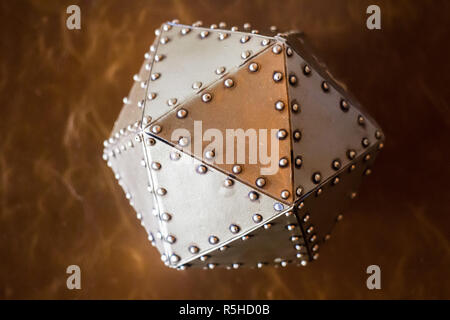 Metal hexagon ball on brown leather background Stock Photo