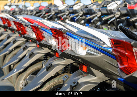 New motorcycles parked in a row on the sidewalk, transportation background Stock Photo