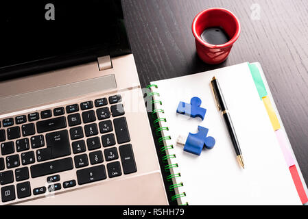 still life with blocknote, labtop, pen and a red cup of coffee over a black office desk. symbol of job Stock Photo