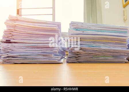 documents on desk stack up high waiting to be managed Stock Photo