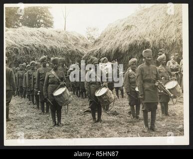 Indian infantry band playing on a French farm [St Floris, France]. Band of the 40th Pathans playing to French peasants, 23rd July 1915. Record of the Indian Army in Europe during the First World War. 20th century, 23rd July 1915. Gelatin silver prints. Source: Photo 24/(44). Author: Girdwood, H. D. Stock Photo