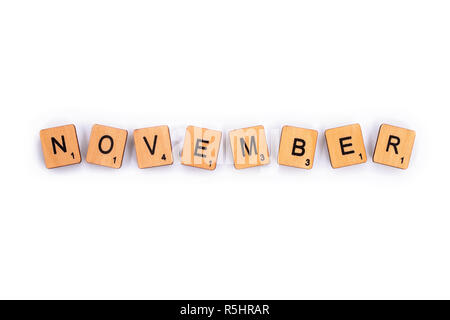 London, UK - July 8th 2018: NOVEMBER, spelt with wooden letter tiles over a plain white background. Stock Photo