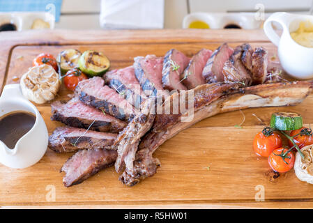 Grilled tomahawk steak on wooden plate Stock Photo