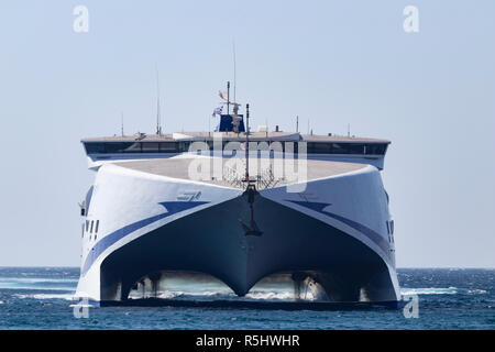 Ferry sails toward a Greek island on the Aegean Sea in front view,  August 2018 Stock Photo