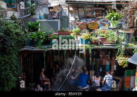BUDAPEST, HUNGARY - August 12, 2018: Tourists sit under a roof on a hot sunny day in Szimpla kert ruin pub and farmers market, one of the most popular Stock Photo